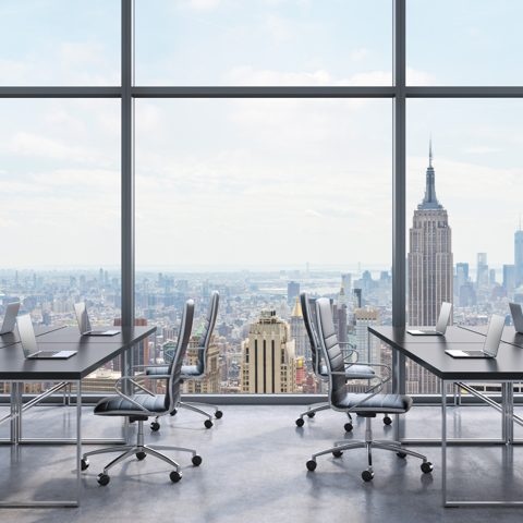Oficina con ventanales y vista a una ciudad