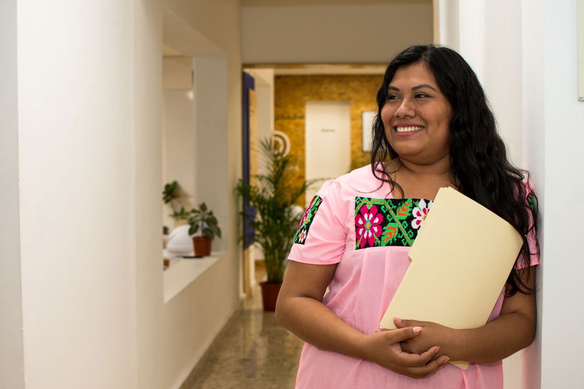 Mujer sonriente con una carpeta de documentos en una oficina